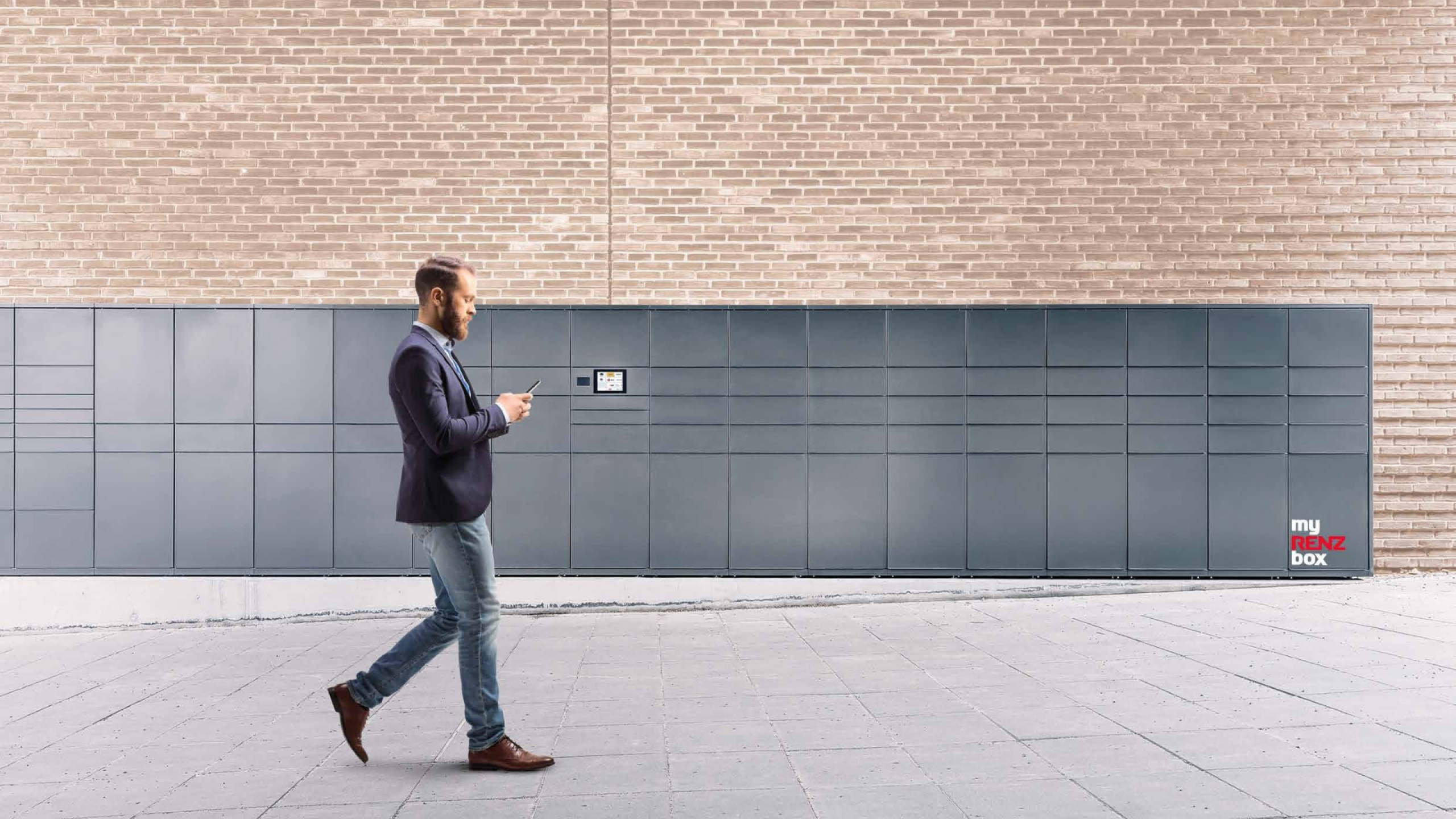 Uomo che utilizza lo smartphone davanti a una stazione di ricezione automatizzata myRENZbox grigio antracite installata all'esterno.